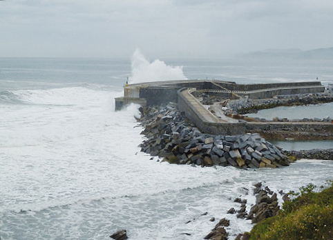 Das
                        vollendete Wellenkraftwerk von Mutriku (Motrico)
                        mit der Turbinenhalle, im Schutzdeich
                        integriert, Sicht vom Ufer aus