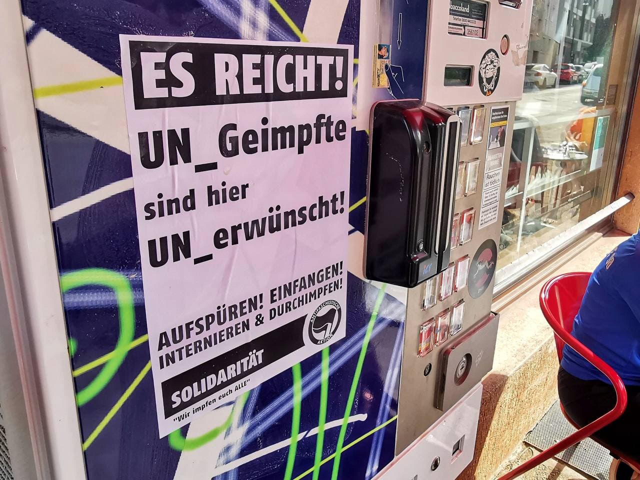 Kriminell-zionistische Antifa mit Plakaten
                      gegen UNgeimpfte in Geschäften