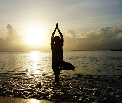 Joga: Oberschenkel-Quadrizeps
                                      dehnen am Strand mit
                                      Sonnenuntergang