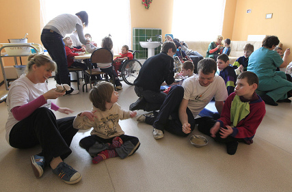 7. Mittagspause: Die Betreuer aus
                              Irland fttern zusammen mit dem
                              einheimischen Personal die Kinder.