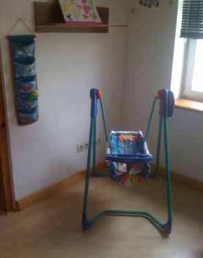 Baby swing on a metal
                              rack in the house (indoor), Graco Company