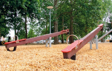 Seesaw 02 made of wood
                            with soft rubber buffer on a sawdust ground,
                            Claramatte Park ("Clara Meadow
                            Park"), Basel