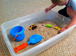 Un cajn de arena en la casa 02 con
                                autos de juego, con una excavadora de
                                juego y con una aleta
