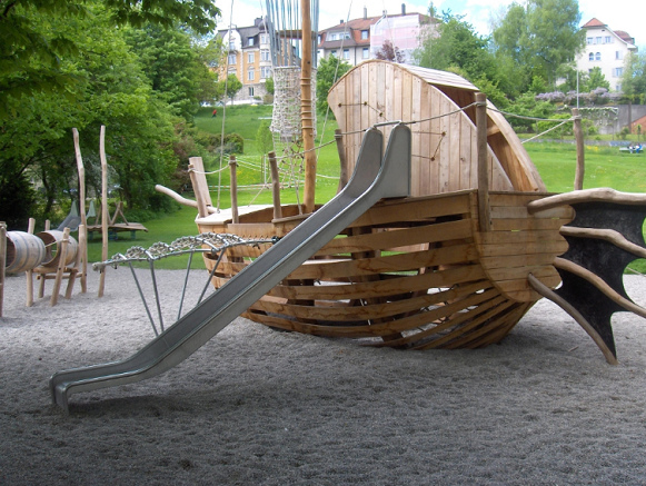 Barco
                            volante en el parque infantil
                            "Kollerwiese" ("Prado de
                            Koller") 01 en el distrito de Wiedikon
                            en Zurich, Suiza, la vista de atrs con el
                            tobogn