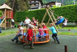 Carrusel infantil en un parque infantil del
                      Oberland berns con nios que juegan
