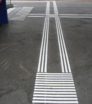 Leitliniensystem (taktil-visuelle
                          Markierungen) in einem Bahnhof zwischen zwei
                          Perrons und vor einer Unterfhrung.